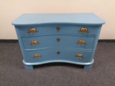An early 20th century painted serpentine fronted three drawer chest with brass porcelain panel