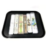 A group of six various Swatch watches in plastic cases.