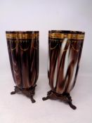 A pair of 19th century hand painted brown glass vases on metal griffin feet,