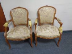 A pair of carved beech framed salon armchairs upholstered in a gold floral fabric