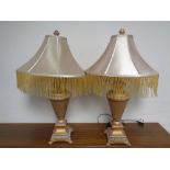 A pair of contemporary classical table lamps with tasselled shades