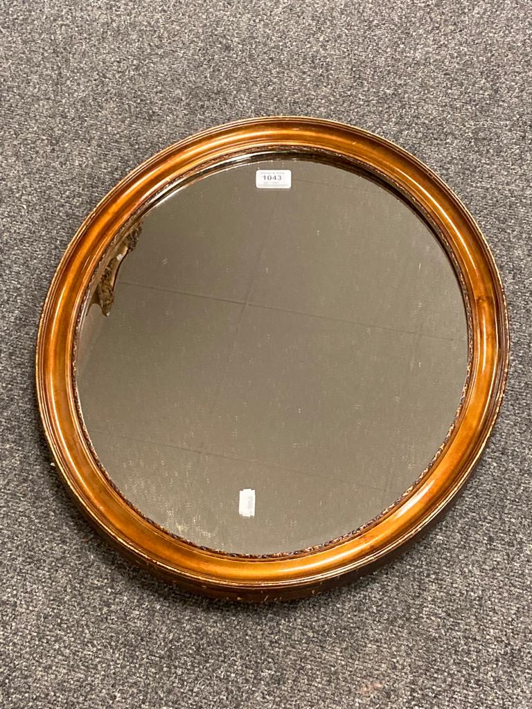 An early twentieth century oval mirror, 47 cm x 57 cm.