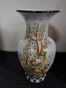 A glazed pottery oriental style vase depicting peacocks,