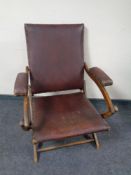 An early 20th century folding campaign style armchair upholstered in a vinyl