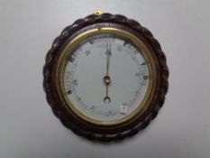 A carved oak circular barometer