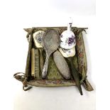 A fabric tray containing silver plated and petit point dressing table brushes,