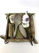 A fabric tray containing silver plated and petit point dressing table brushes,