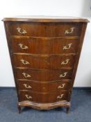 A mid 20th century continental serpentine fronted six drawer chest with brass handles