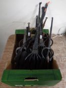 A box containing a quantity of wrought iron eel forks