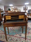 A 20th century continental mahogany barrel fronted writing bureau on raised legs