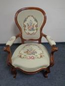 A carved beech framed French salon armchair upholstered in a tapestry fabric