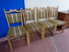A set of four blonde oak dining chairs upholstered in a green striped fabric