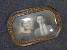 An antiquarian colour photograph depicting a lady and gentleman in a gilt frame with convex glass