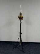 A wrought iron and brass standard oil lamp