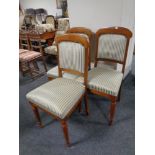 A set of three antique dining chairs upholstered in a classical striped fabric