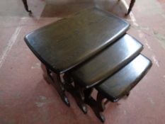 A nest of three Ercol solid stained elm and beech tables