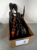 A box containing carved tribal tourist figures