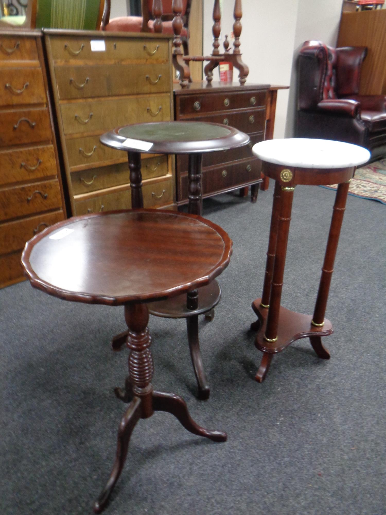 A marble topped plant stand together with two wine tables on tripod bases