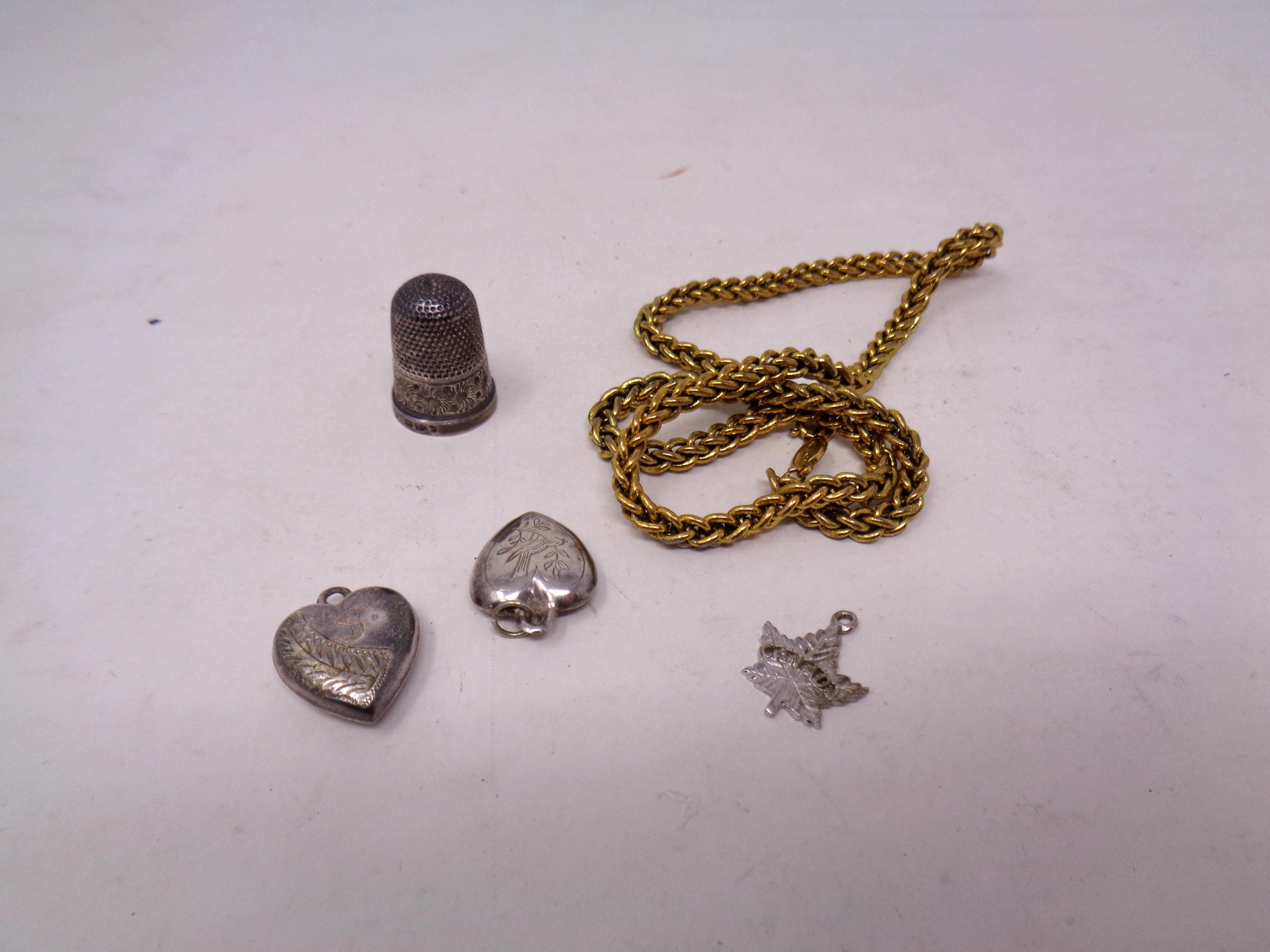 A silver thimble together with locket,