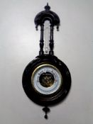 A carved ebonised barometer with enamel dial