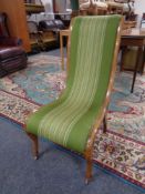 A nursing chair upholstered in a green striped fabric