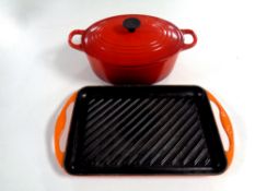 A cast iron Le Creuset lidded cooking pot together with a Le Cruset cast iron skillet pan