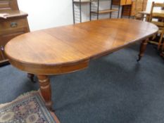 A 19th century oak wind out table, two extension leaves and winder,