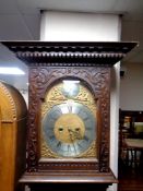 A 19th century heavily carved oak longcase clock with brass and silvered dial by Henrich Dreier,