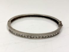 A silver bangle with channel set stones