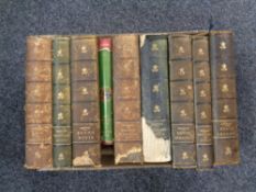 A box of eight antiquarian leather bound volumes including Dickens and a further volume;