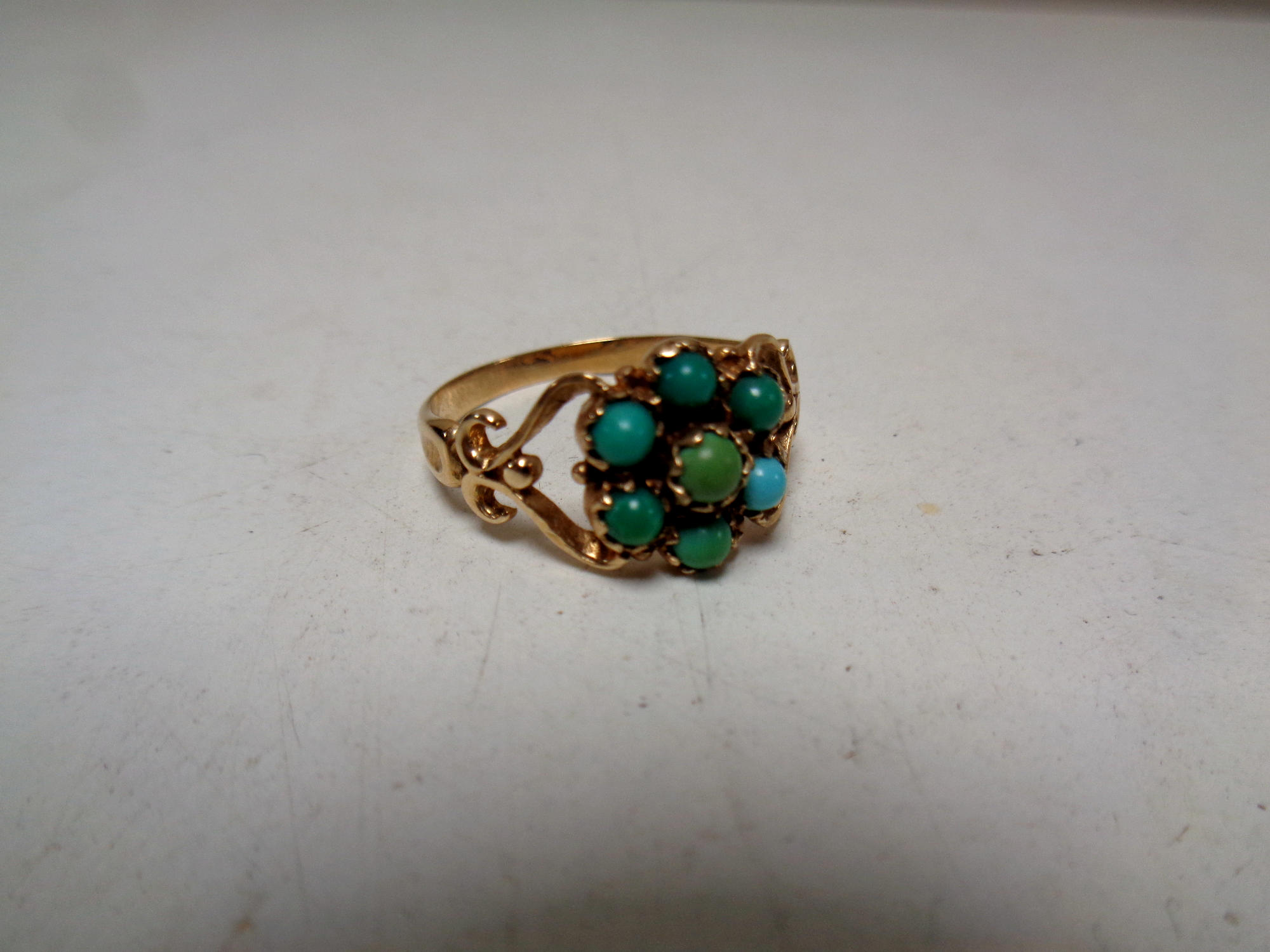 An antique turquoise cluster ring, marks rubbed.