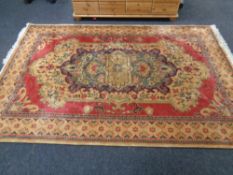 A Persian design fringed carpet on gold ground,