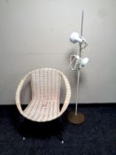 A mid 20th century rattan armchair and a floor standing spot lamp