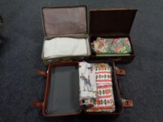 Three luggage cases containing material and linen