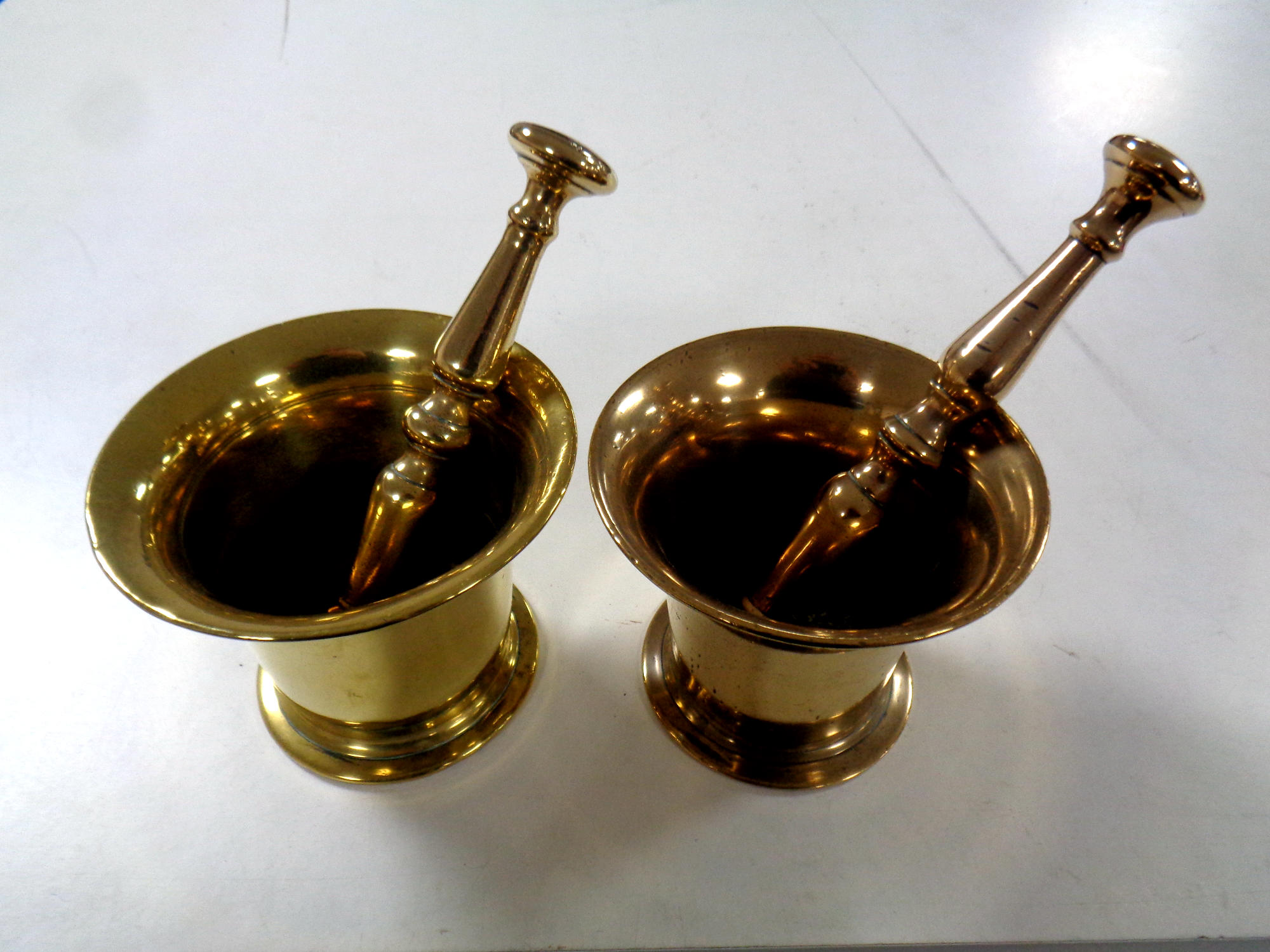 Two antique brass pestles and mortars.