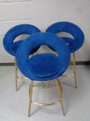 A set of three contemporary bar chairs upholstered in a blue fabric on metal legs
