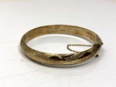 A rolled gold bangle with textured decoration