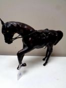 A vintage leather horse figure with foot raised, height 26 cm.