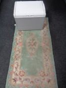 A large freezer box and a Chinese rug on green ground