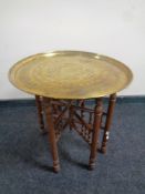 A folding Eastern brass topped table