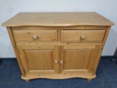 A stripped pine serpentine fronted double door sideboard,