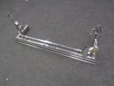 A chrome Art Deco fire curb with companion pieces