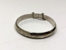 A sterling silver bangle with safety chain