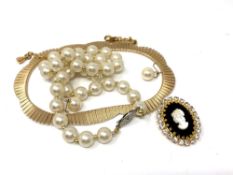 A flat link gold plated necklace together with costume pearls,