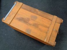 A wooden crate with metal carrying handles