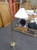 An antique brass rise and fall standard lamp on paw feet