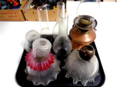 A tray of antique copper and brass oil lamp base with chimney together with three further oil lamp