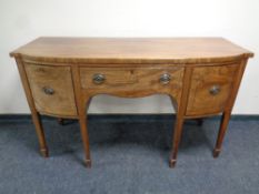 A 19th century mahogany bow-fronted triple door sideboard on raised legs
