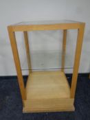 A square oak shop display stand with two glass shelves