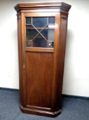 A late 19th century corner hall wardrobe with astral glazed doors,